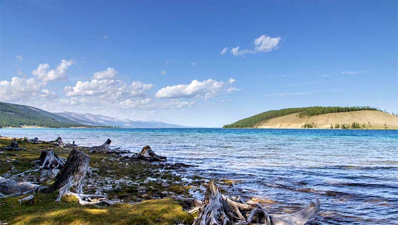 Jazero Chövsgöl v Mongolsku s čistou vodou, horským horizontom a skalnatým brehom