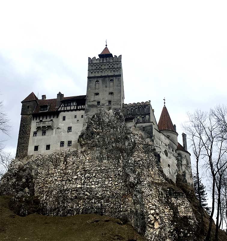Hrad Bran na skalnom útese, historická pevnosť v Rumunsku, dramatický pohľad zdola