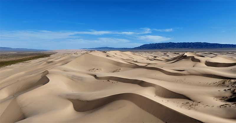 Piesočné duny púšte Gobi v Mongolsku s vlnitým reliéfom krajiny