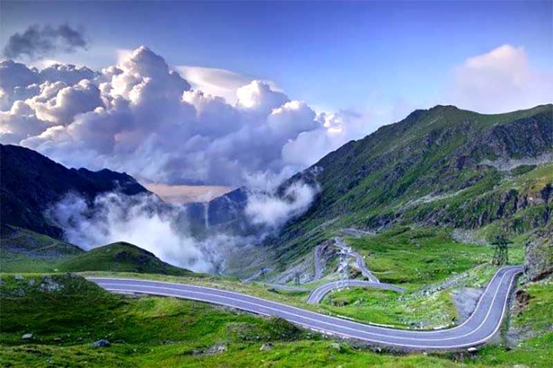 Transfagarašská magistrála kľukatiaca sa cez horské sedlo, dramatická cesta v rumunských Karpatoch s mrakmi a hmlou