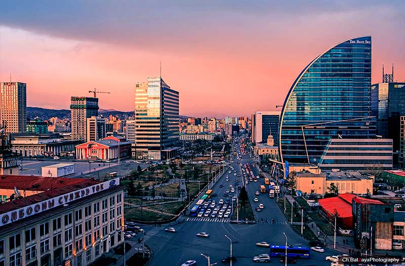 Centrum Ulánbátaru v Mongolsku pri západe slnka s modernými budovami a rušnou dopravou