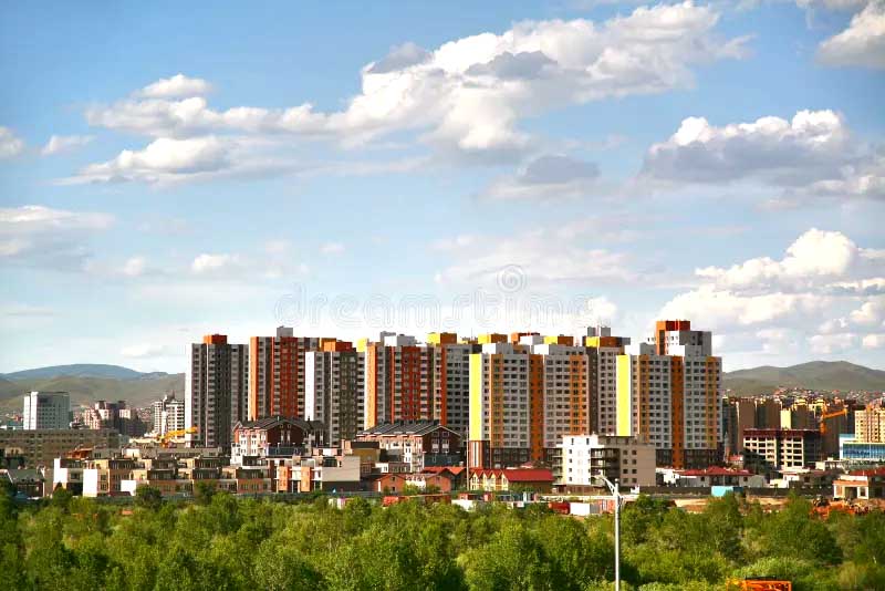 Obytná štvrť Ulánbátaru v Mongolsku s panelovými domami a horským horizontom