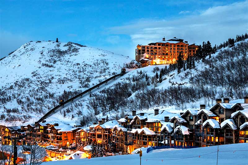 Zimné stredisko Deer Valley v Utahu s osvetlenými horskými hotelmi a zasneženými svahmi