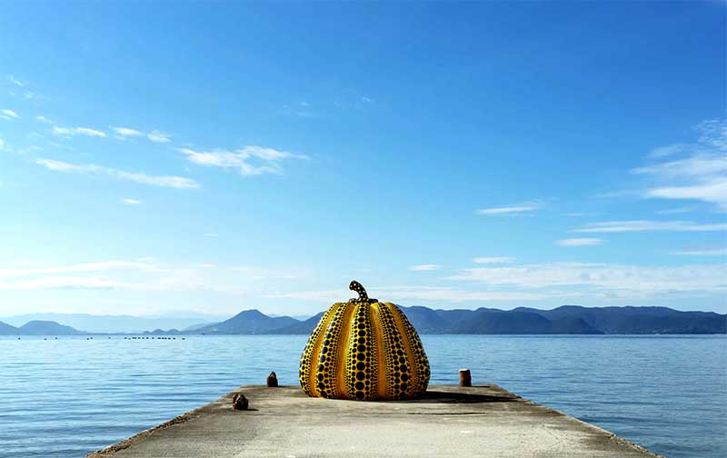 Tekvicová socha Yayoi Kusama na móle pri mori na ostrove Naoshima v Japonsku