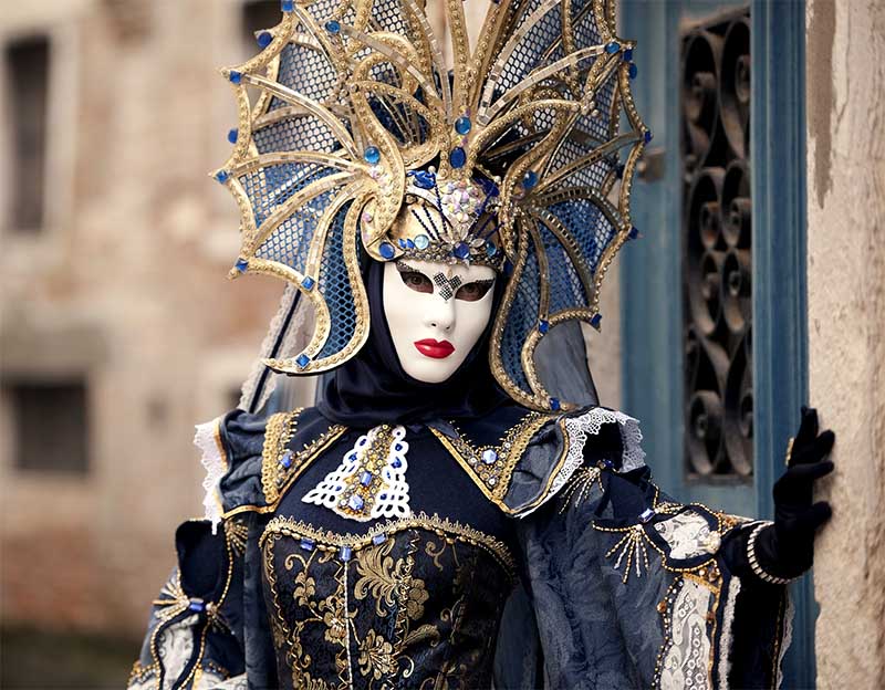 Elegantná maska Benátskeho karnevalu s bohato zdobenou zlatou a modrou pokrývkou hlavy