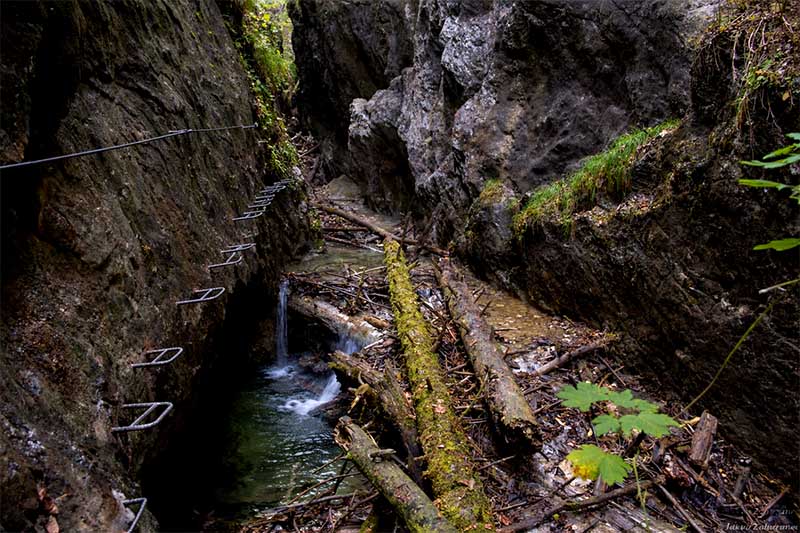 Ferrata Kyseľ bez ľudí, kovové stupačky na skalnej stene nad potokom v tiesňave Slovenský raj