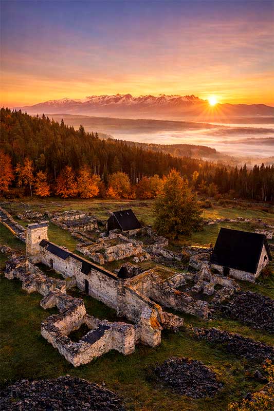 Kláštorisko pri východe slnka, zrúcaniny kartuziánskeho kláštora v Slovenskom raji s horským horizontom v pozadí