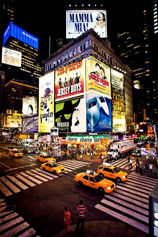 Moderný Times Square v noci s LED billboardmi, taxíkmi a tisíckami ľudí