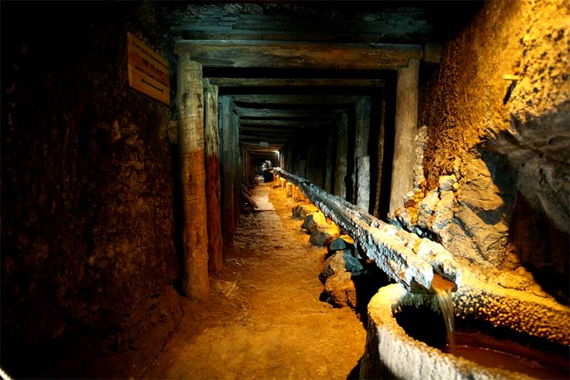Historická soľná chodba v Soľnej bani Wieliczka s drevenými výstuhami a odtokom vody