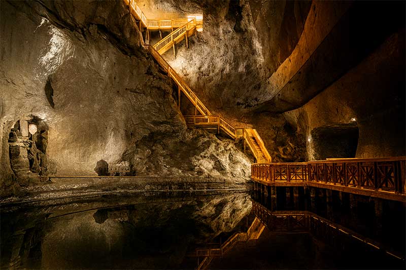 oľná baňa Wieliczka podzemné jazero so schodiskami a odrazom svetla v slanej vode